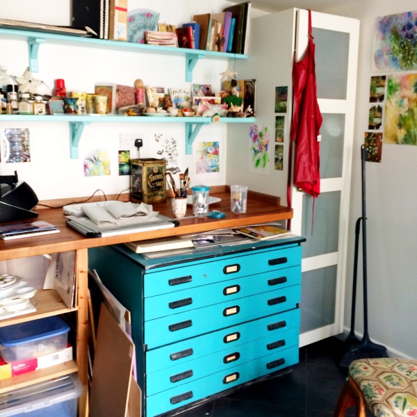 Shelves, worktables and paintings inside the garden studio